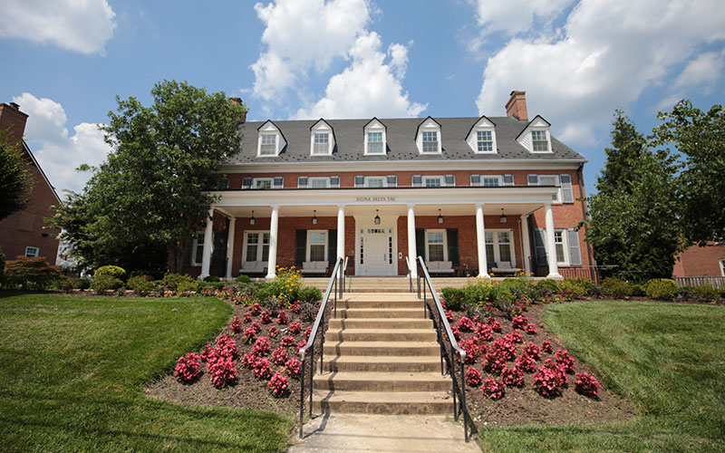 Brick house at 4516 Knox Road with window shutters, white columns, and a front entrance framed by colorful flowerbeds