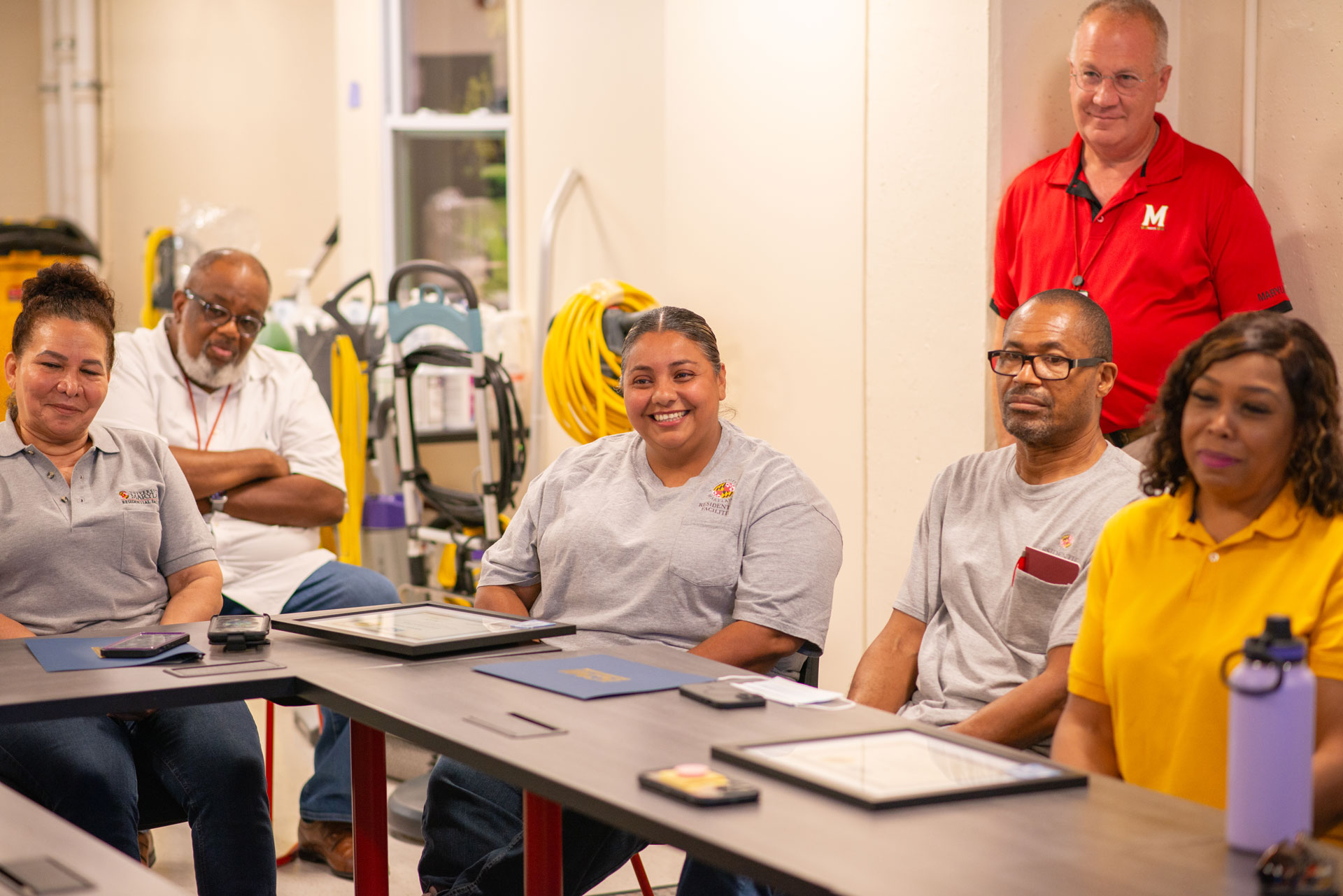 Housekeeping team in basement of residence hall during certification ceremony