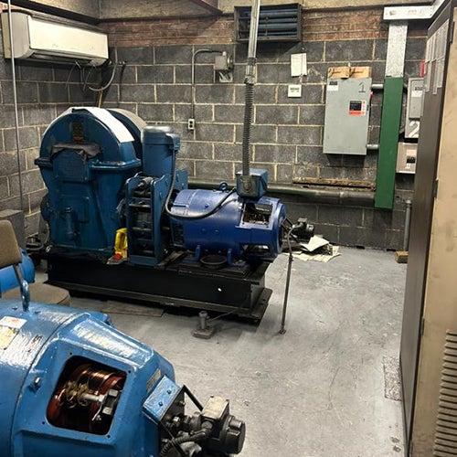 machine room with a pair of large, blue industrial motors and other equipment.