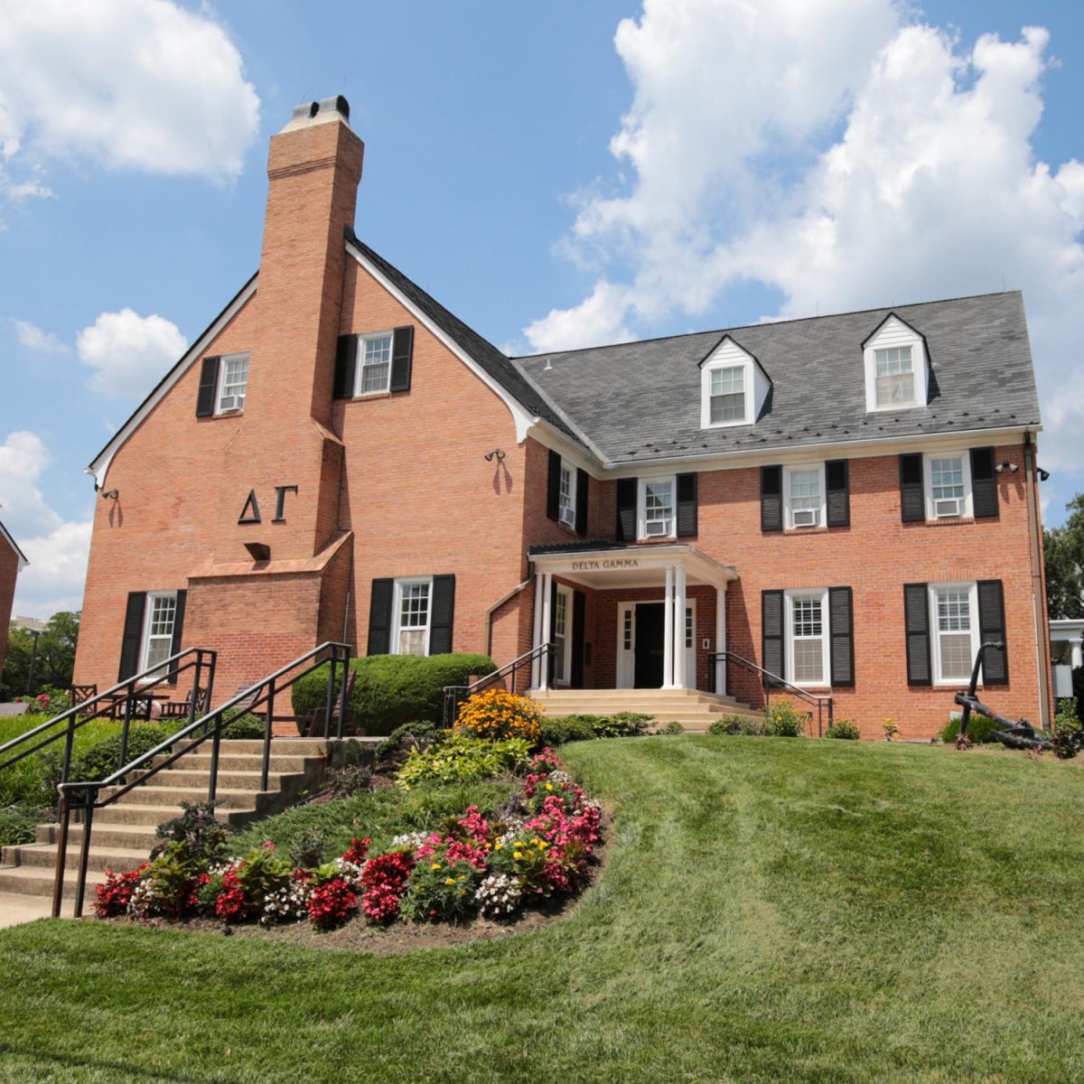 Brick house at 4518 Knox Road with window shutters, white columns, and a front entrance framed by colorful flowerbeds