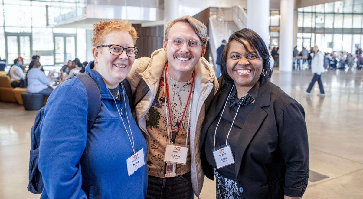 trish lay, joshua beeson, and angela jackson smiling and posing in main atrium during learning day