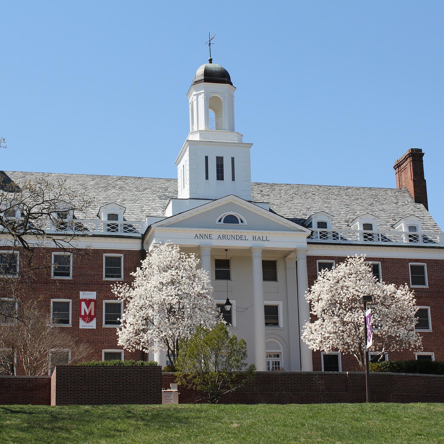 Anne Arundel Hall, a traditional-style dormitory building at the University of Maryland, featuring a brick facade, large windows, and a central entrance with a decorative archway.