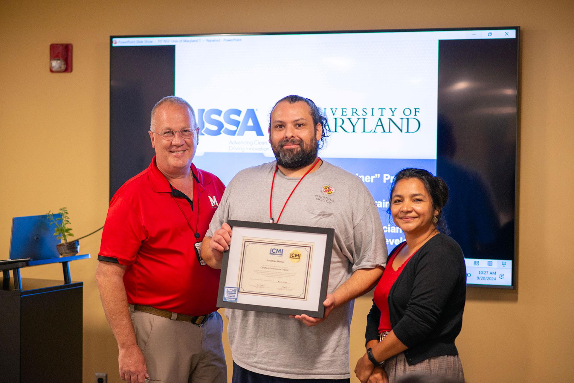 Johnathan Marius  receiving certification from Vassie Hollamon and Isabel Marroquin