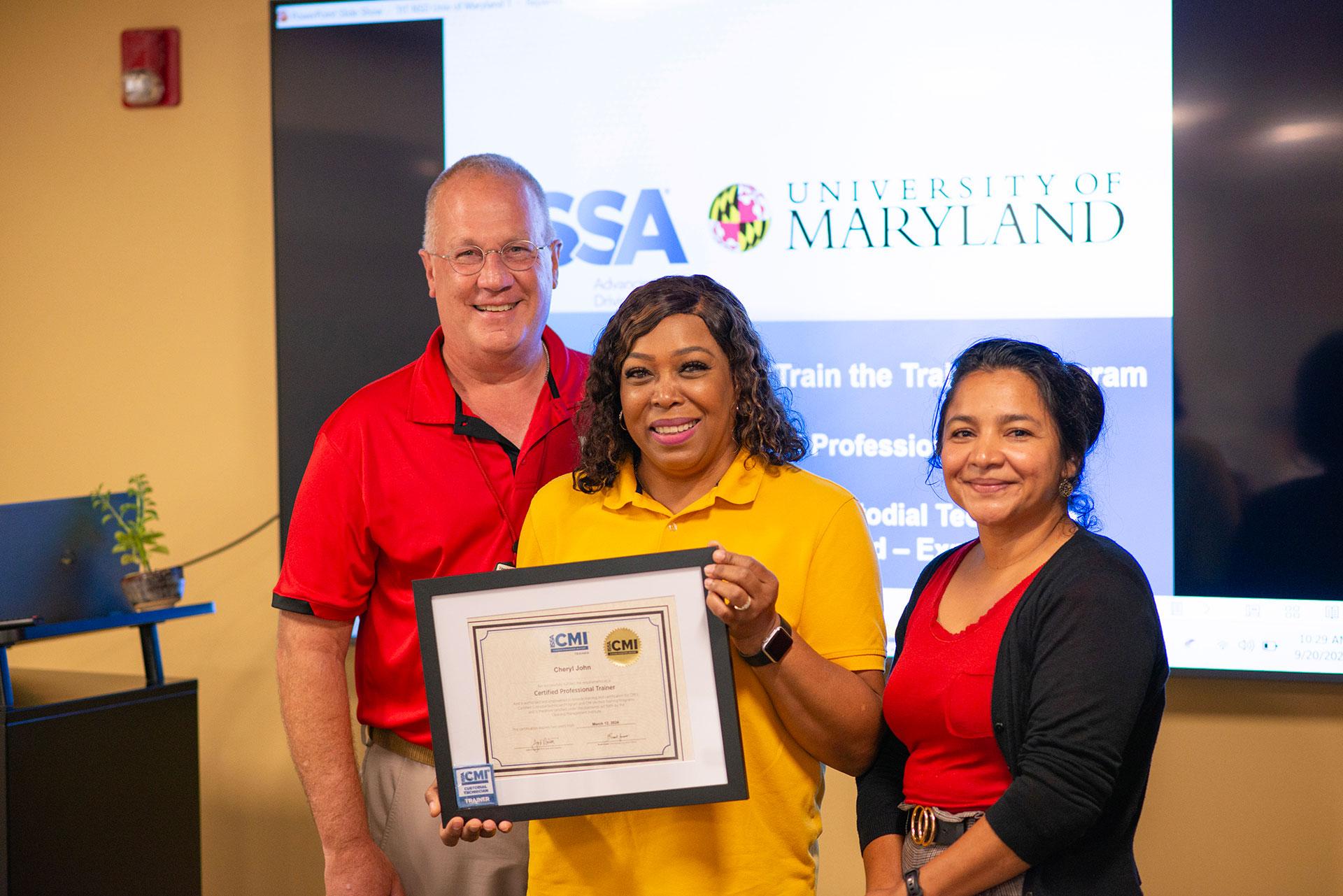 Cheryl John  receiving certification from Vassie Hollamon and Isabel Marroquin