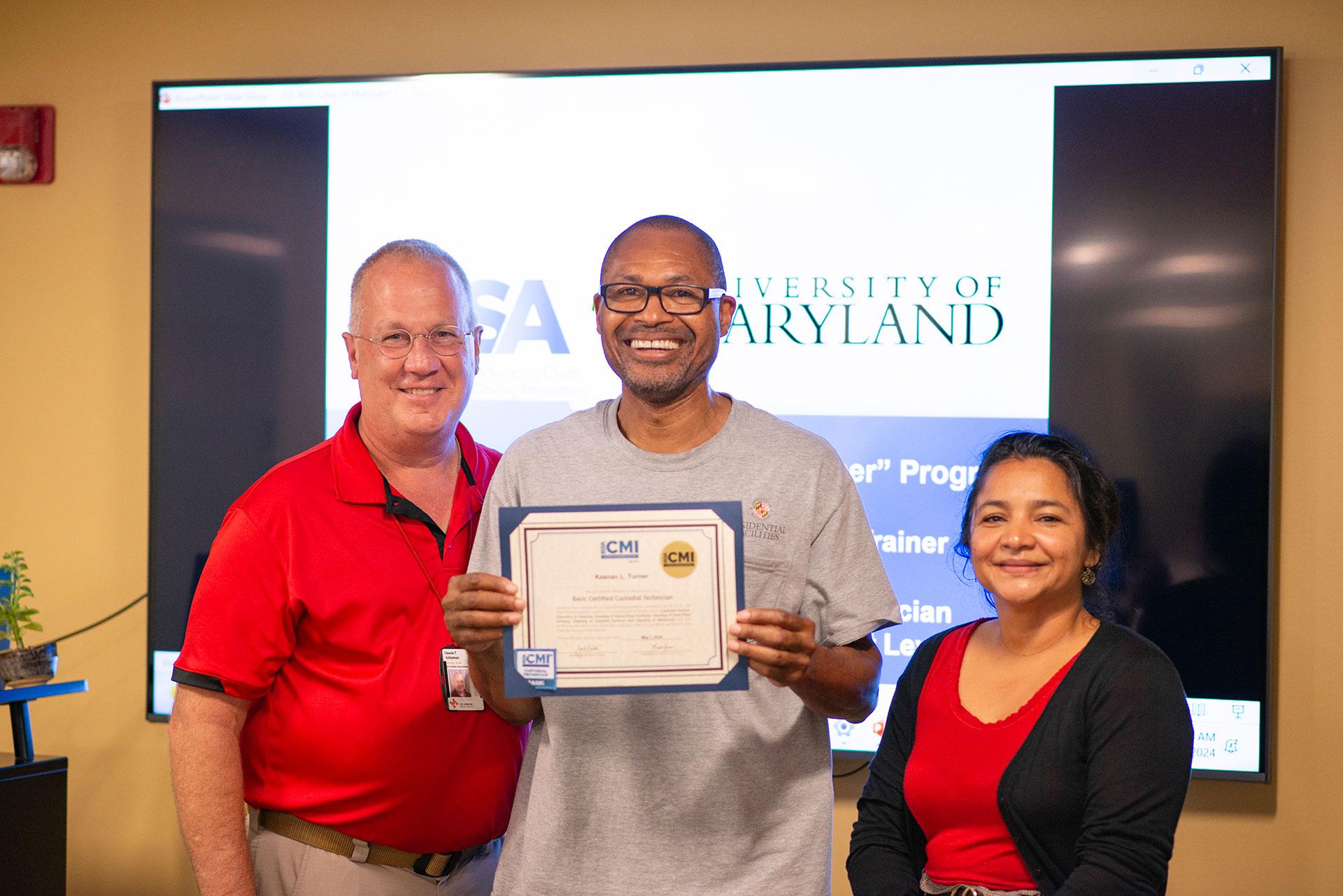 Keenan Turner  receiving certification from Vassie Hollamon and Isabel Marroquin