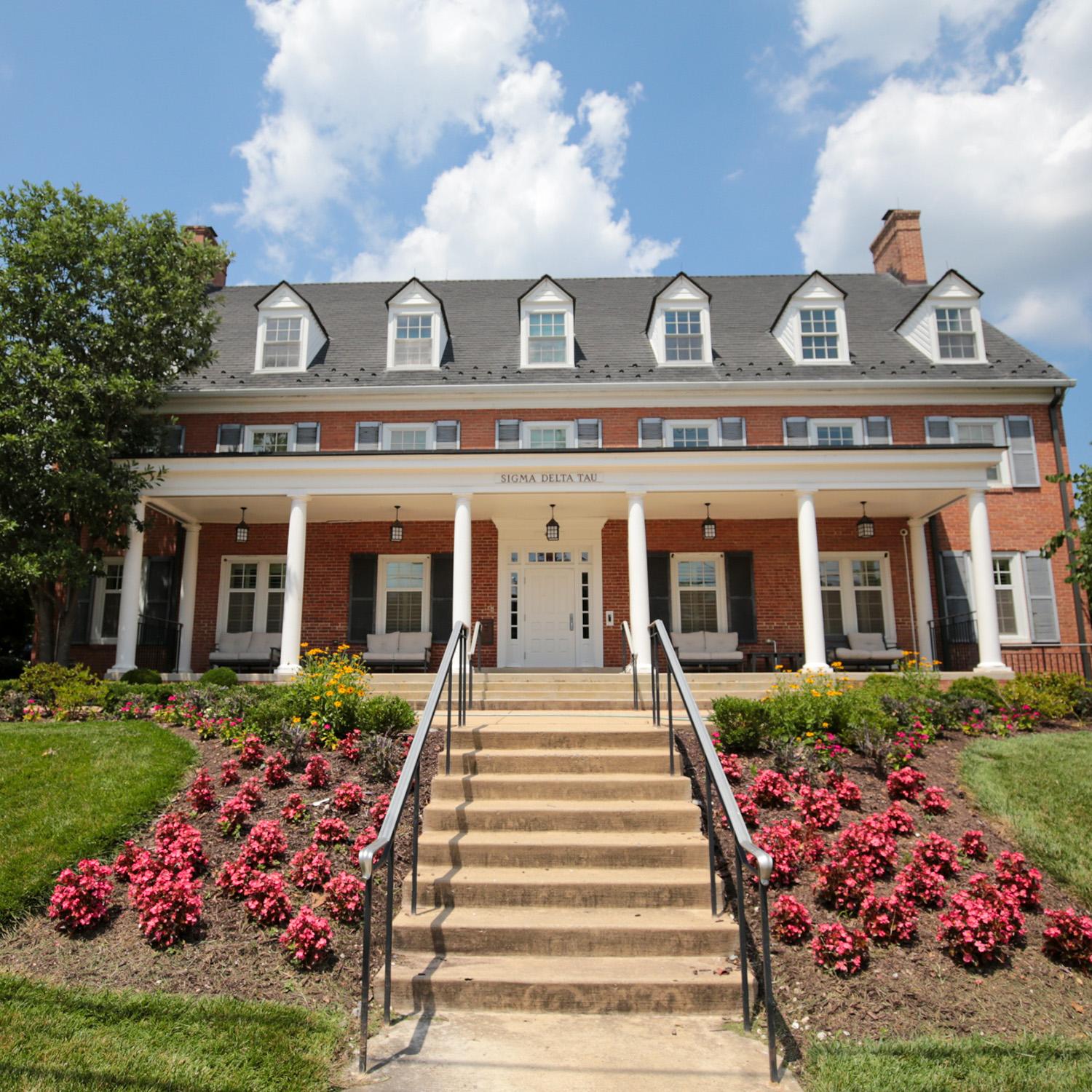 Brick house at 4516 Knox Road with window shutters, white columns, and a front entrance framed by colorful flowerbeds
