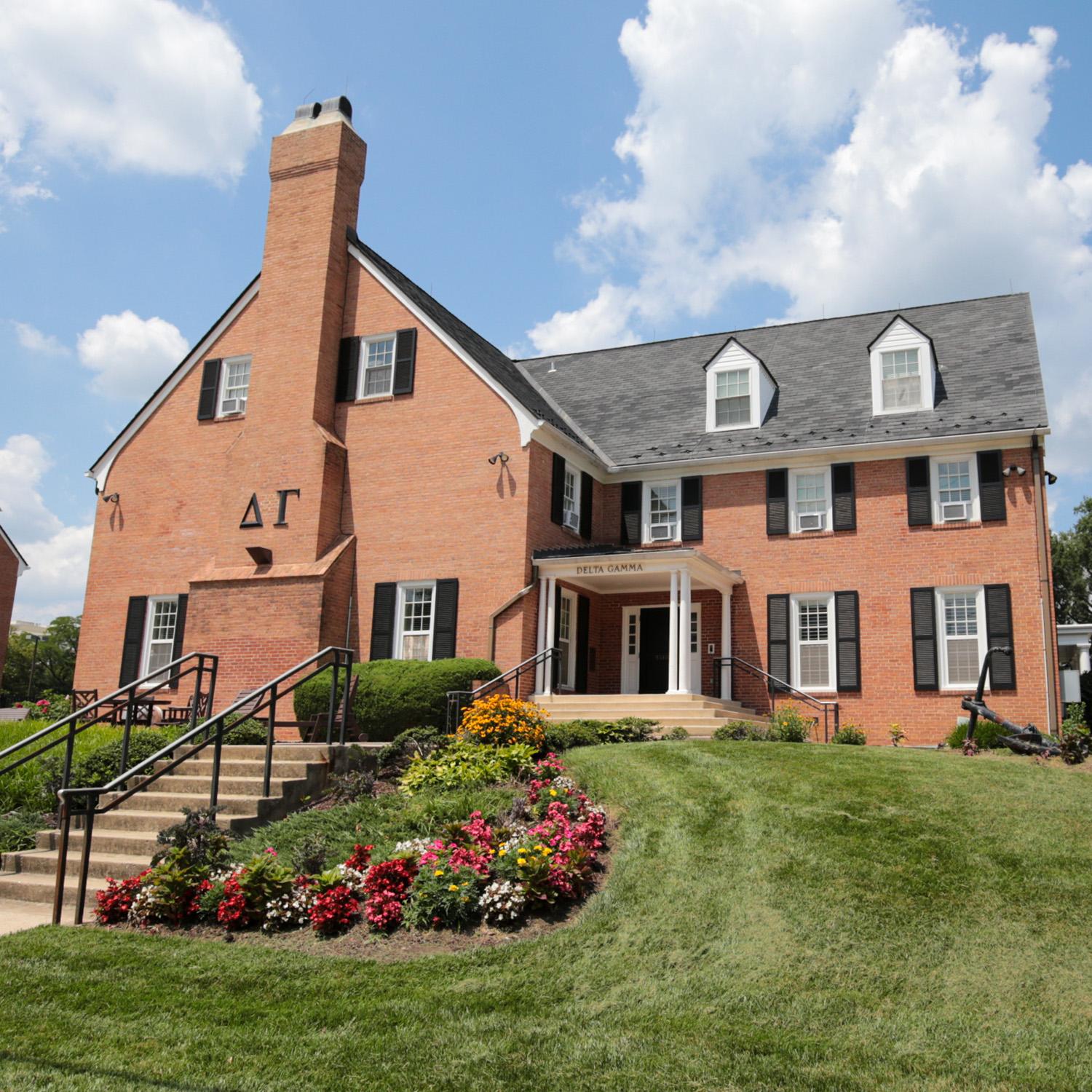 Brick house at 4518 Knox Road with window shutters, white columns, and a front entrance framed by colorful flowerbeds
