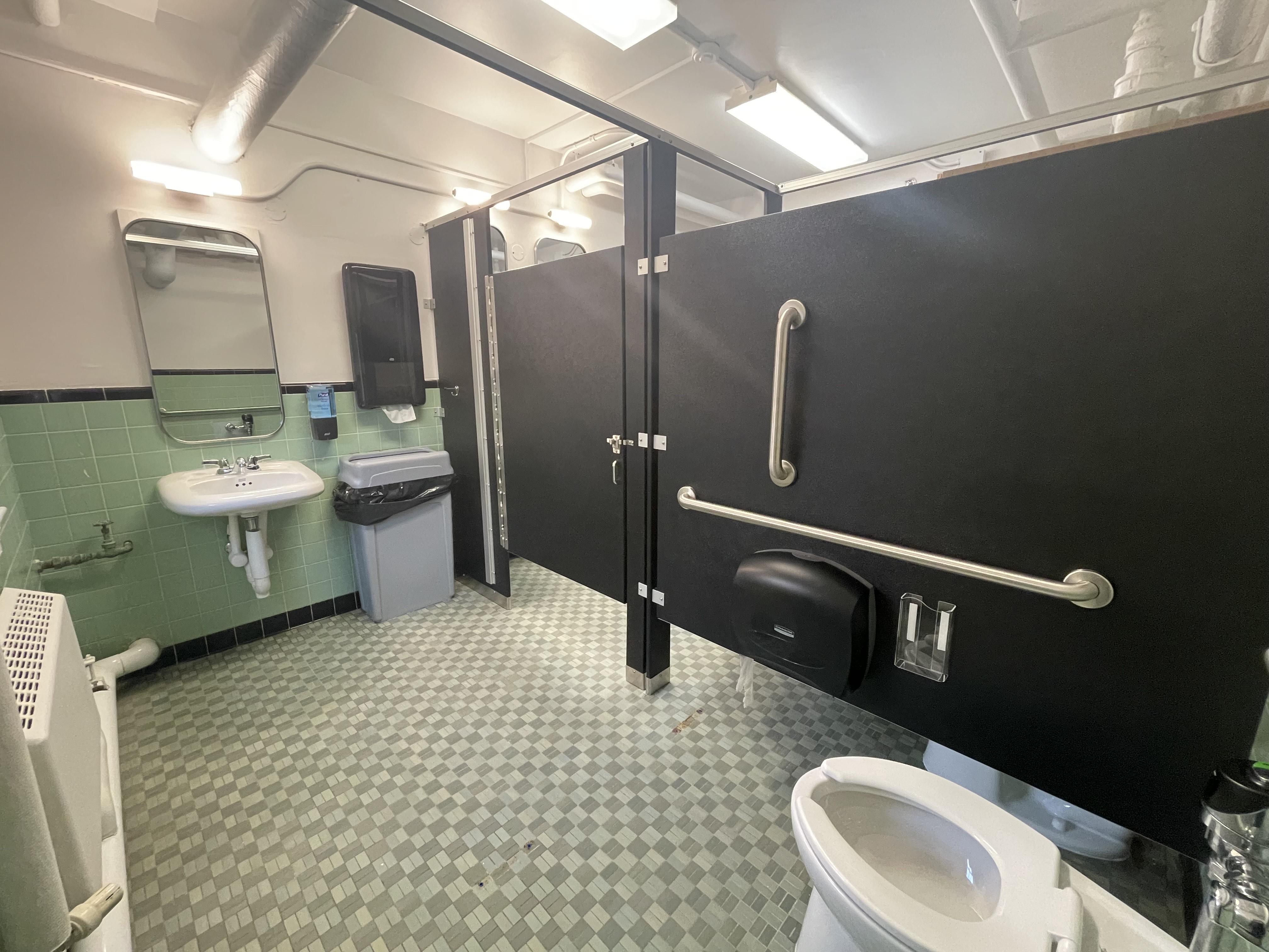 Updated restroom with accessible stall, grab bars and sink area on the ground floor of Caroline Hall.