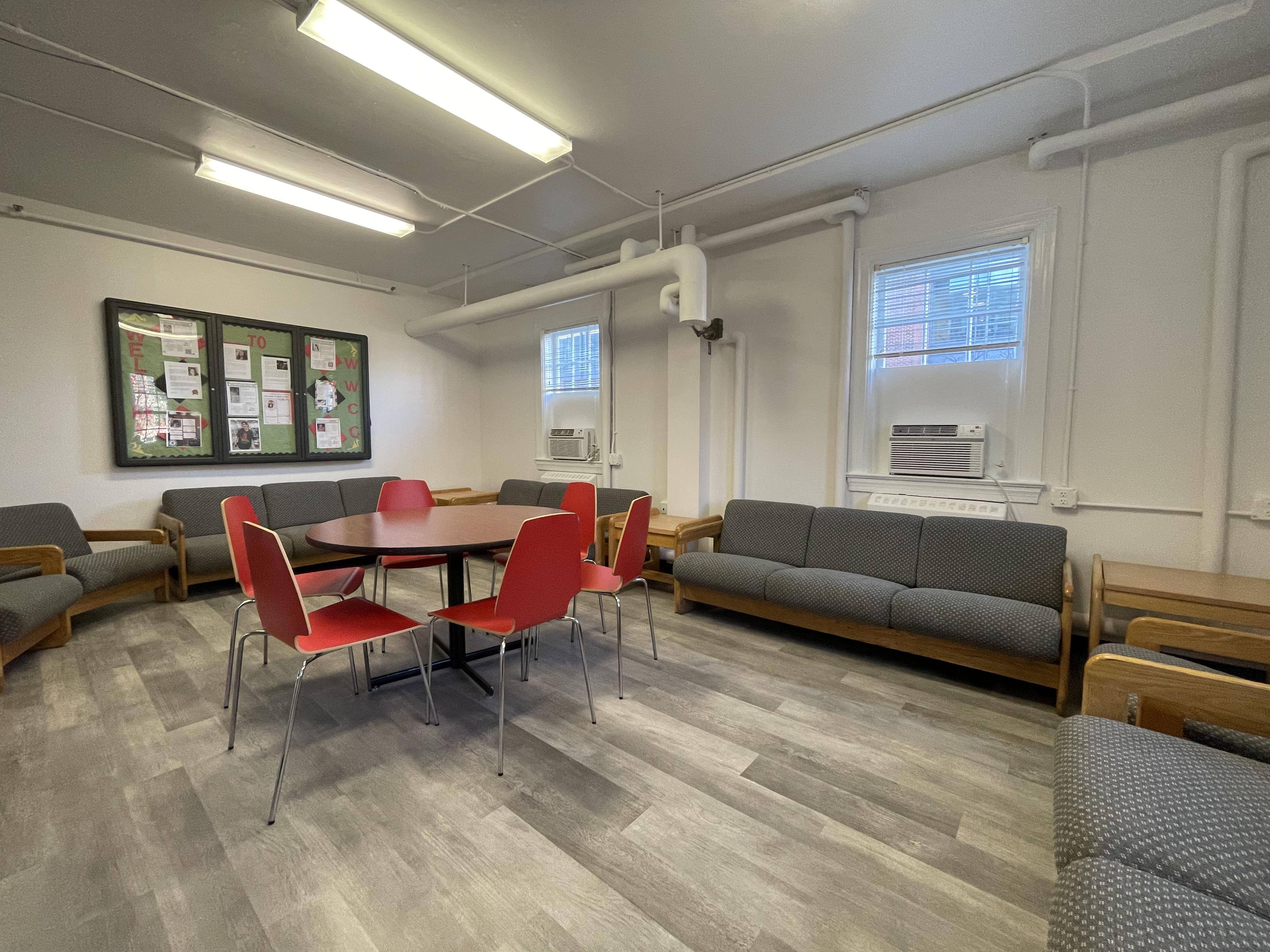 Renovated lounge area with sofas, chairs and a central table, providing a collaborative and welcoming space.